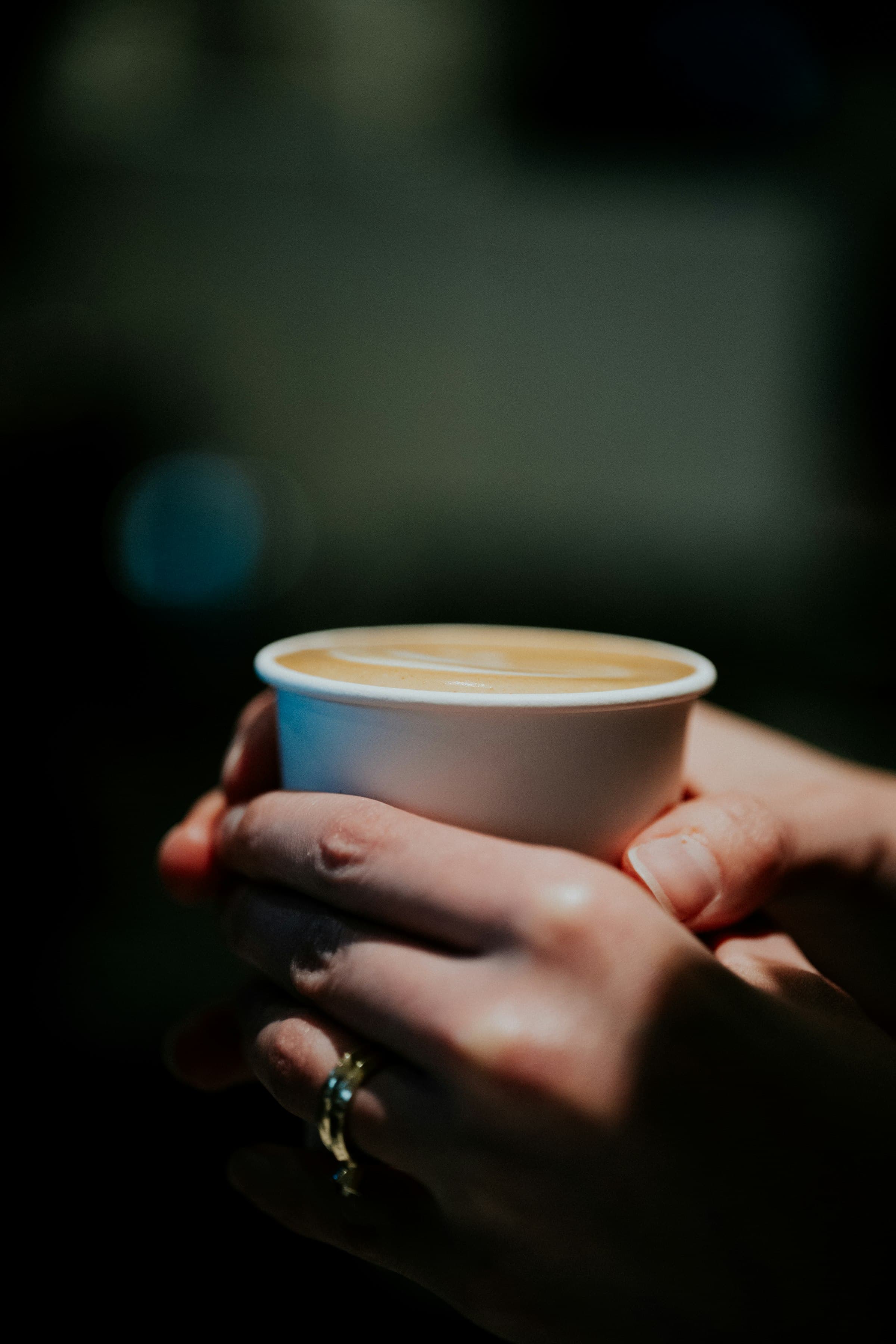 Hands holding a cup of latte art coffee